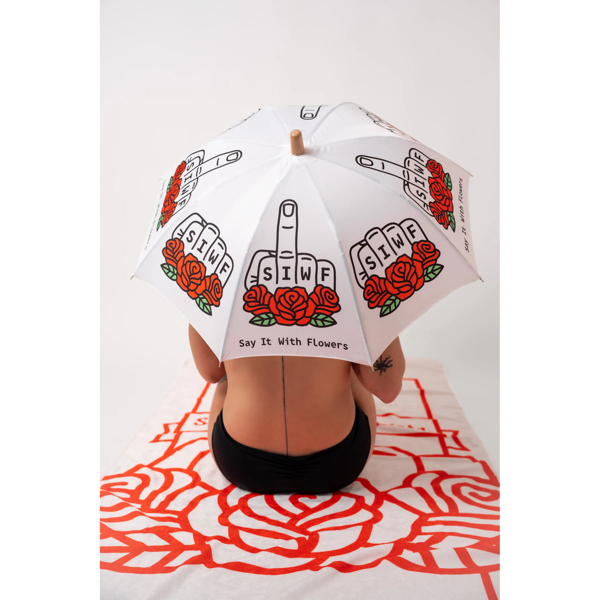 SIWF kids' white umbrella printed with a raised middle finger and red roses